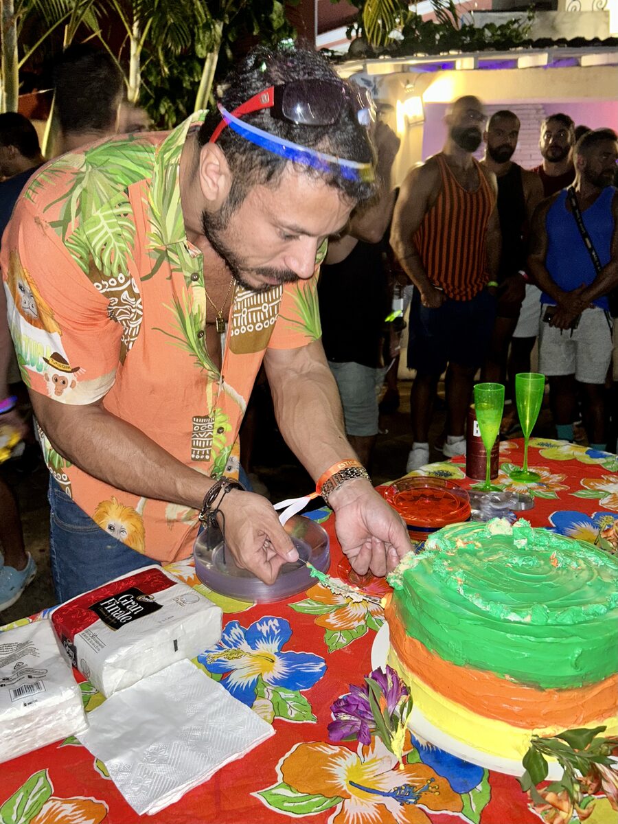 Dois convidados aproveitando o evento com o letreiro iluminado ao fundo